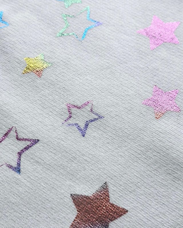 The multi-coloured metallic stars on this jersey fabric have been printed using a foil film, which is available in many widths and colours. An adhesive has to be applied to first, only to the areas that the foil needs to attach to, in order to create the desired pattern. #jersey #jersey fabric #mytrainedeyejersey