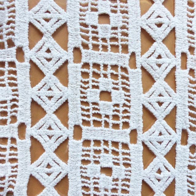 This geometric lace design is knitted on a Raschel warp knit machine, giving the fabric a macramé type appearance. #jerseyfabric #mytrainedeyejersey